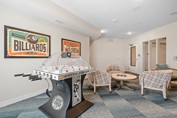a game room with a foosball table and chairs